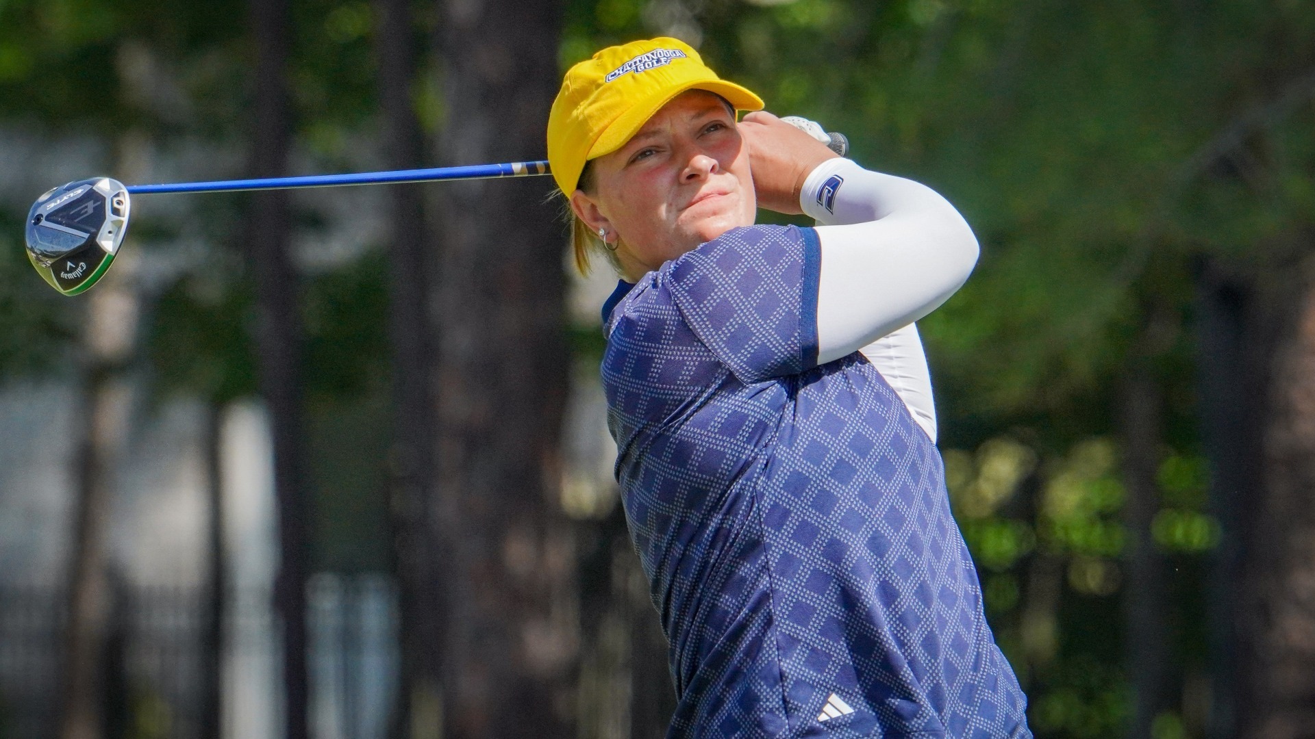 Bella Bugg holds her drive pose as she stares intently at the flight of the ball