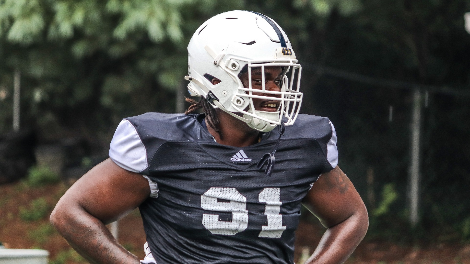 Montrell Henderson looks through his facemask to his left with hands on hips during fall camp 2026