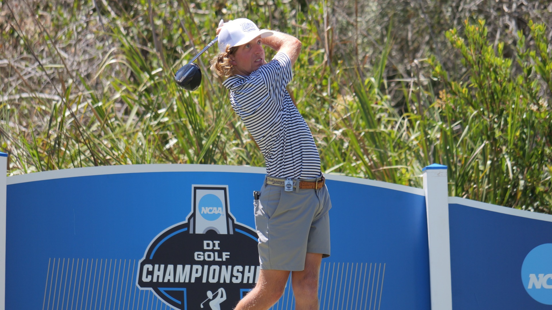 Camden Braidech holds his finish with the driver with NCAA Golf Championships signage in the background at La Costa.