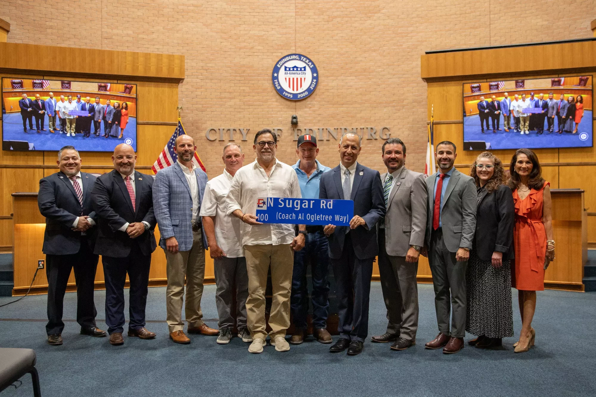 The Edinburg City Council and Mayor present UTRGV baseball alumni and administrators with the Coach Al Ogletree Way sign