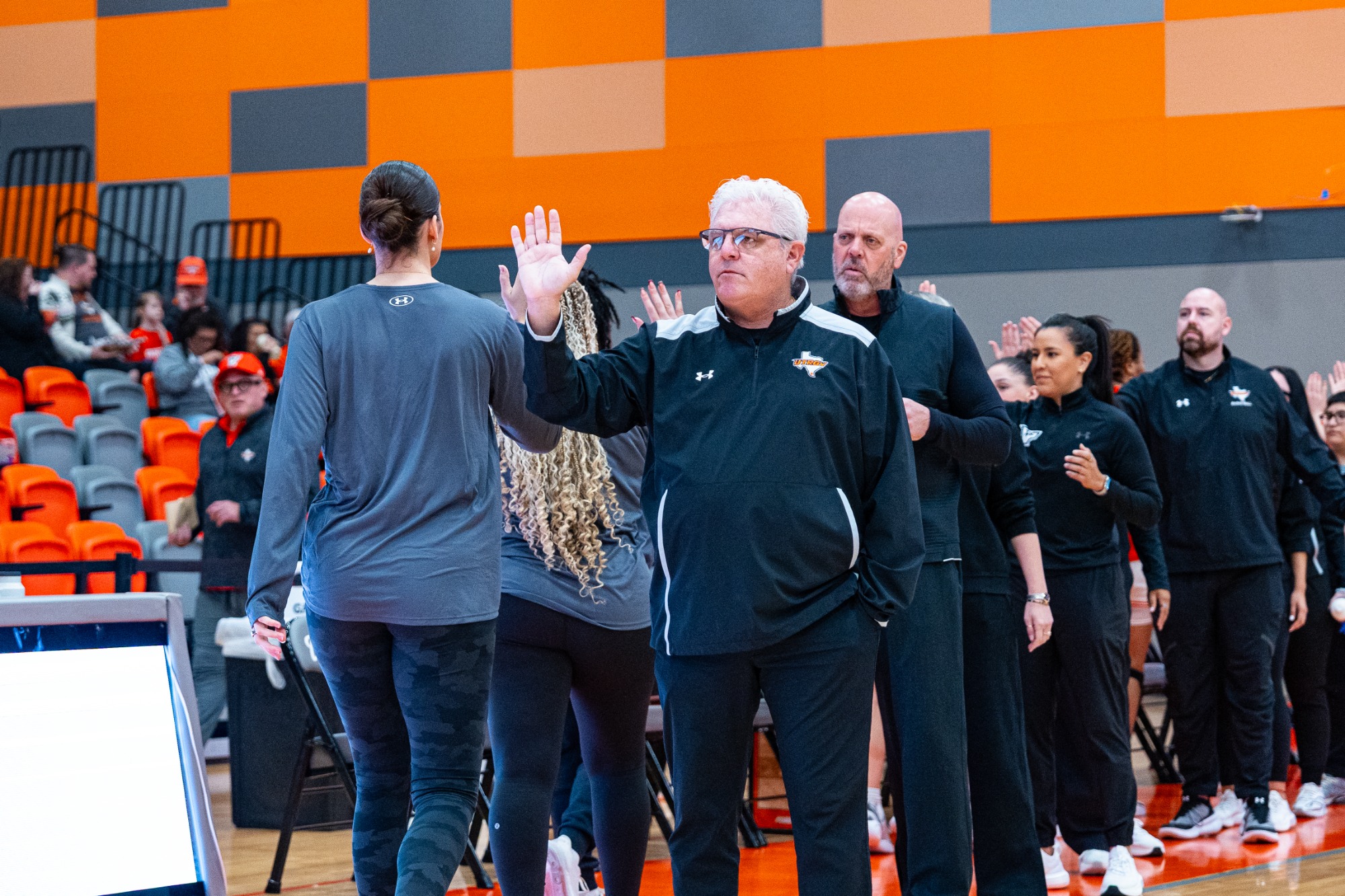 UTRGV Player high fiving Head Coach Lord & team