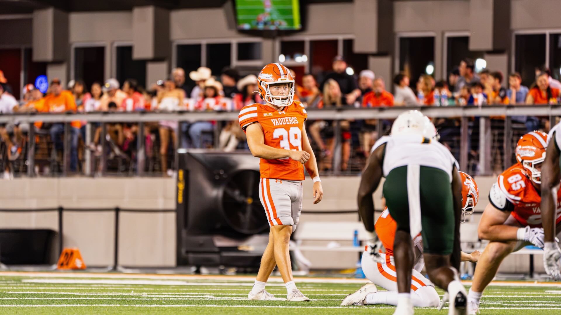 Image shows a kicker preparing to kick on a football field.