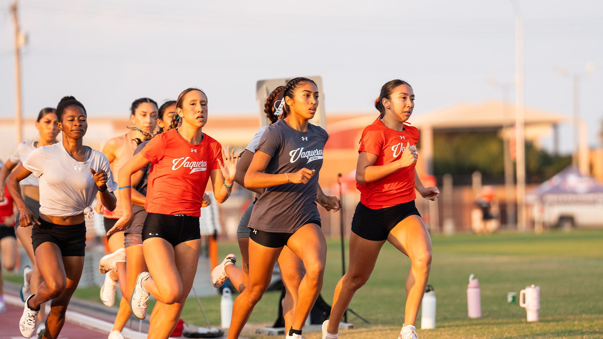A group of women's track & field/cross country student-athletes run on the track during the Orange & Gray Meet