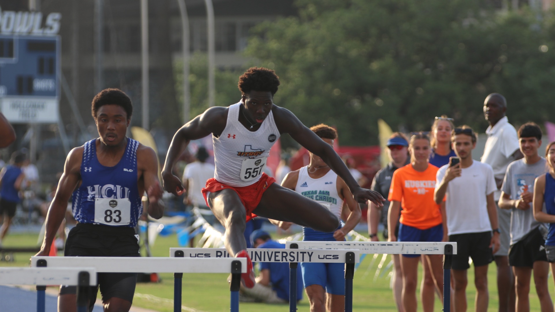 Image is of UTRGV track & field student-athlete Daniel Siaffa clearing a hurdle with runners from other teams also in frame