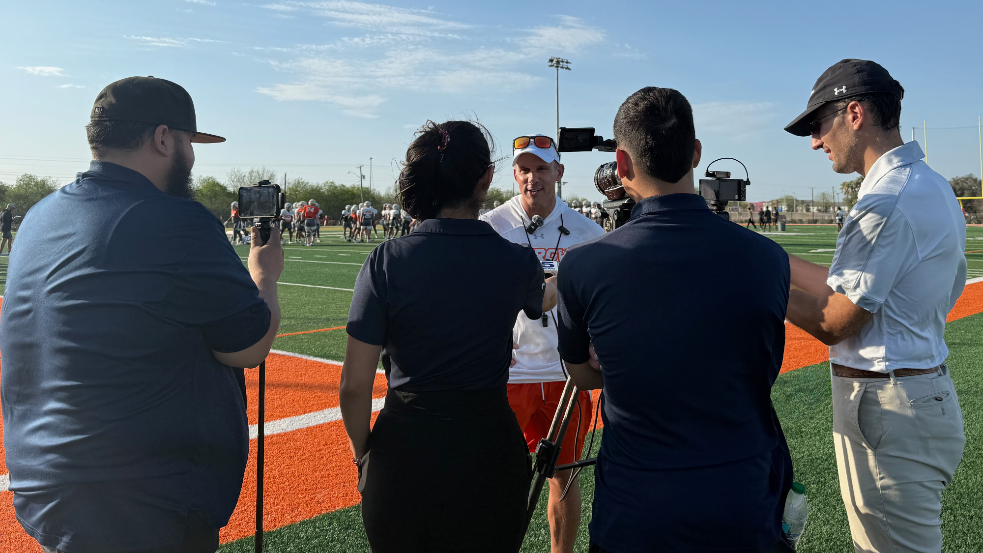 Coach Travis Bush speaking to media during football practice