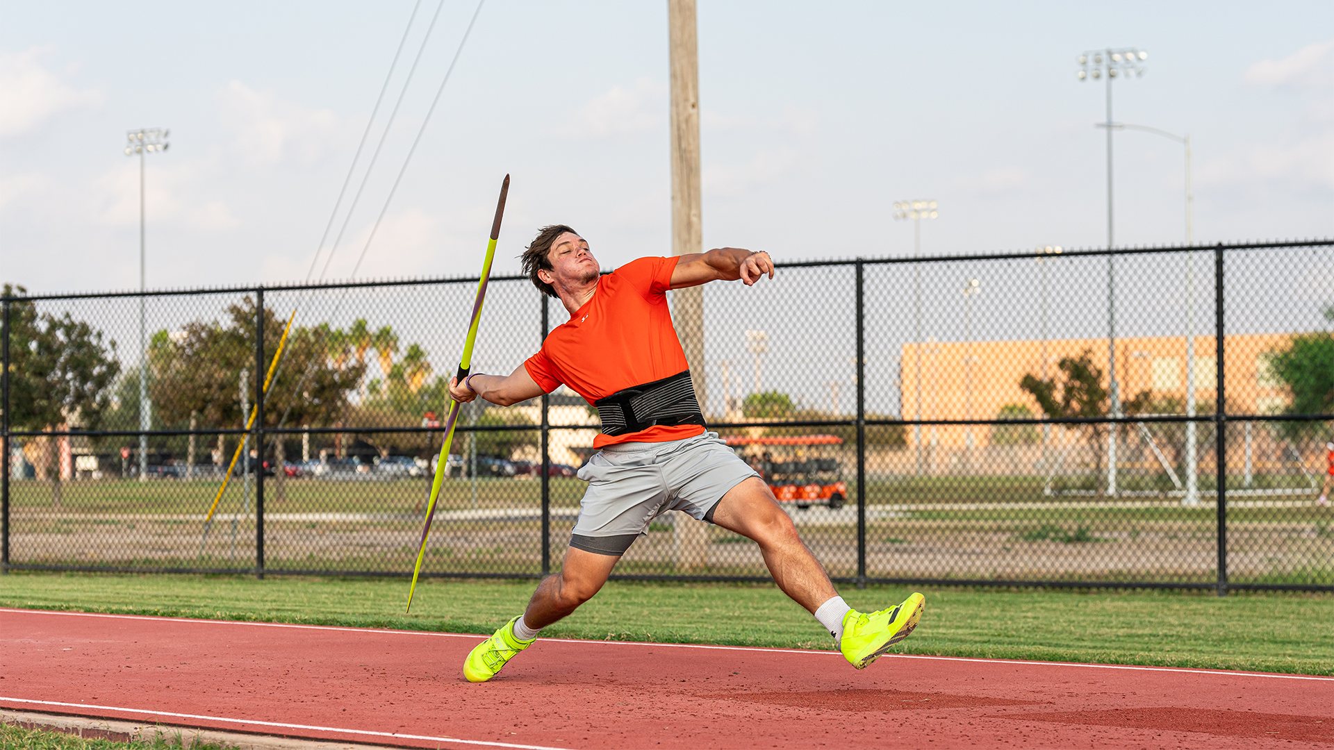 Photo of UTRGV freshman track & field student-athlete Matic Vidmar in an orange shirt and gray shorts preparing to throw the javelin on the runway at UTRGV soccer and track & field complex