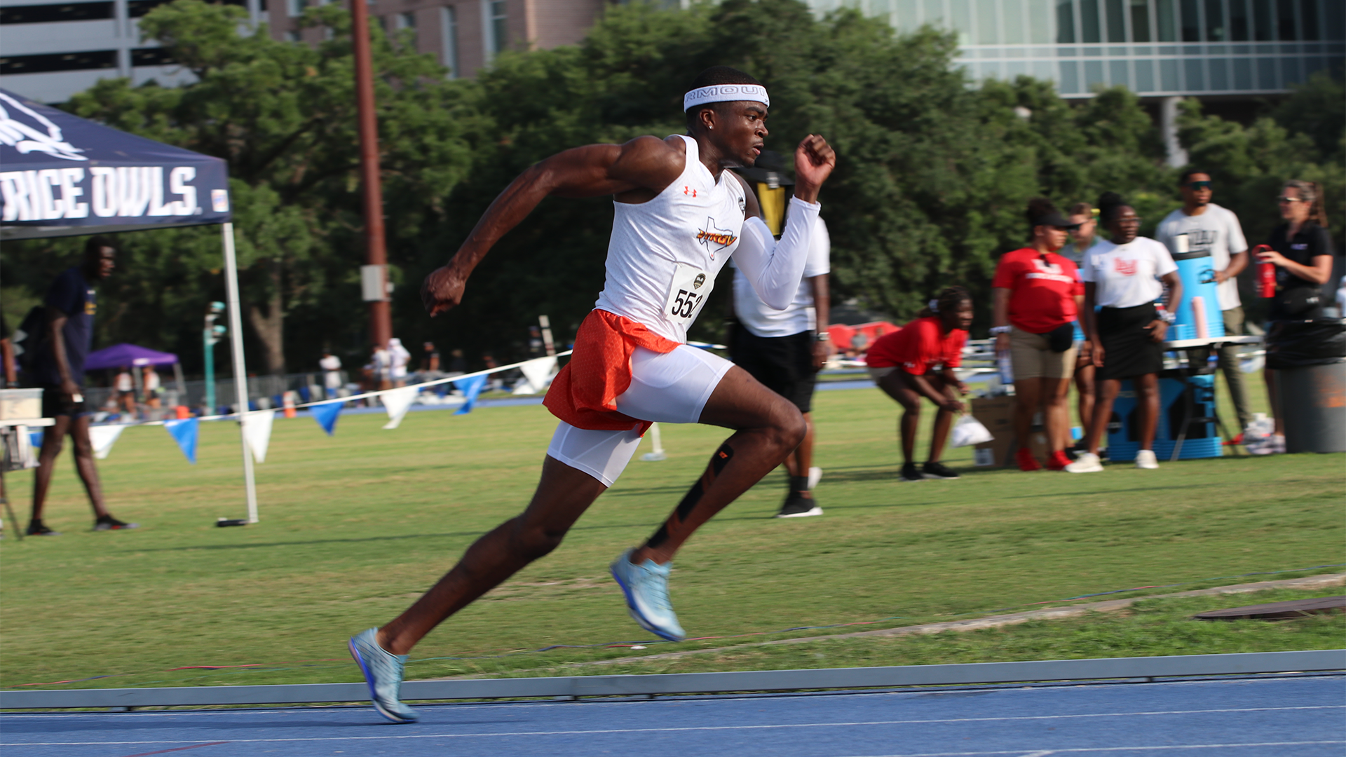 Photo of Derrius Henry in a white track & field uniform top with orange shorts running on a blue track in the 400-meter dash.