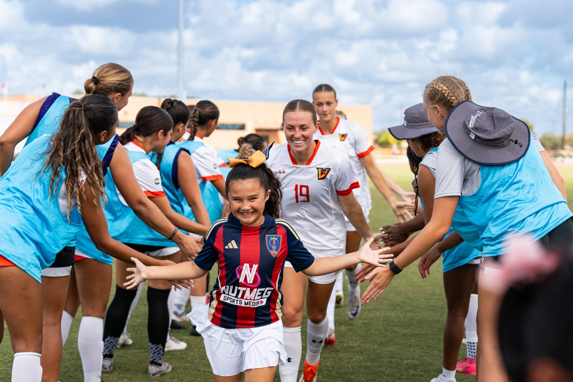 Savannah Frisby running out to team handshakes with kids