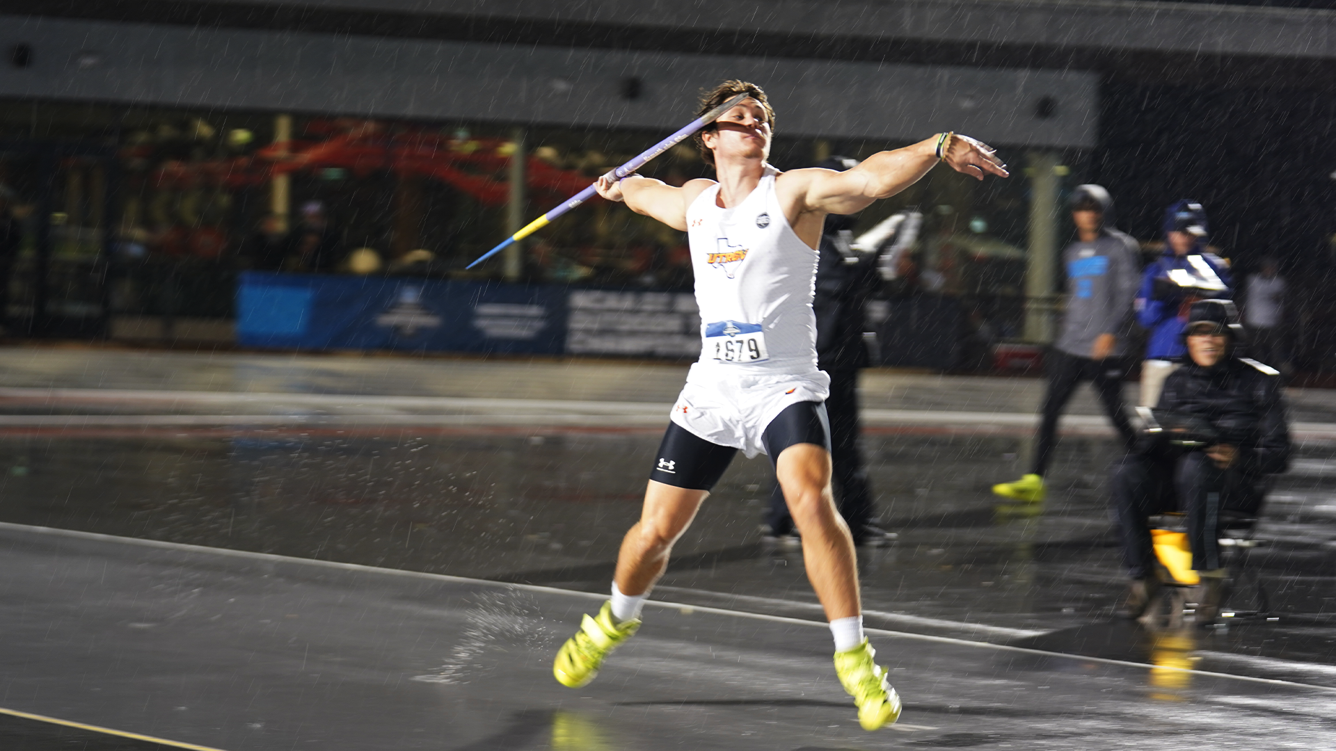 Image shows Matic Vidmar throwing javelin at NCAA West First Round. He is wearing a white UTRGV track & field uniform and holding the javelin in his right arm with his left arm pointing forward as he goes down the track runway.