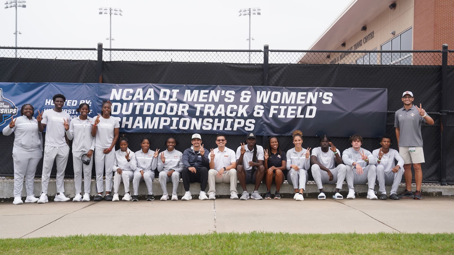 Image shows the 2026 NCAA West First Round qualifiers for the UTRGV track & field team sitting and standing in front of a banner promoting the championship event.