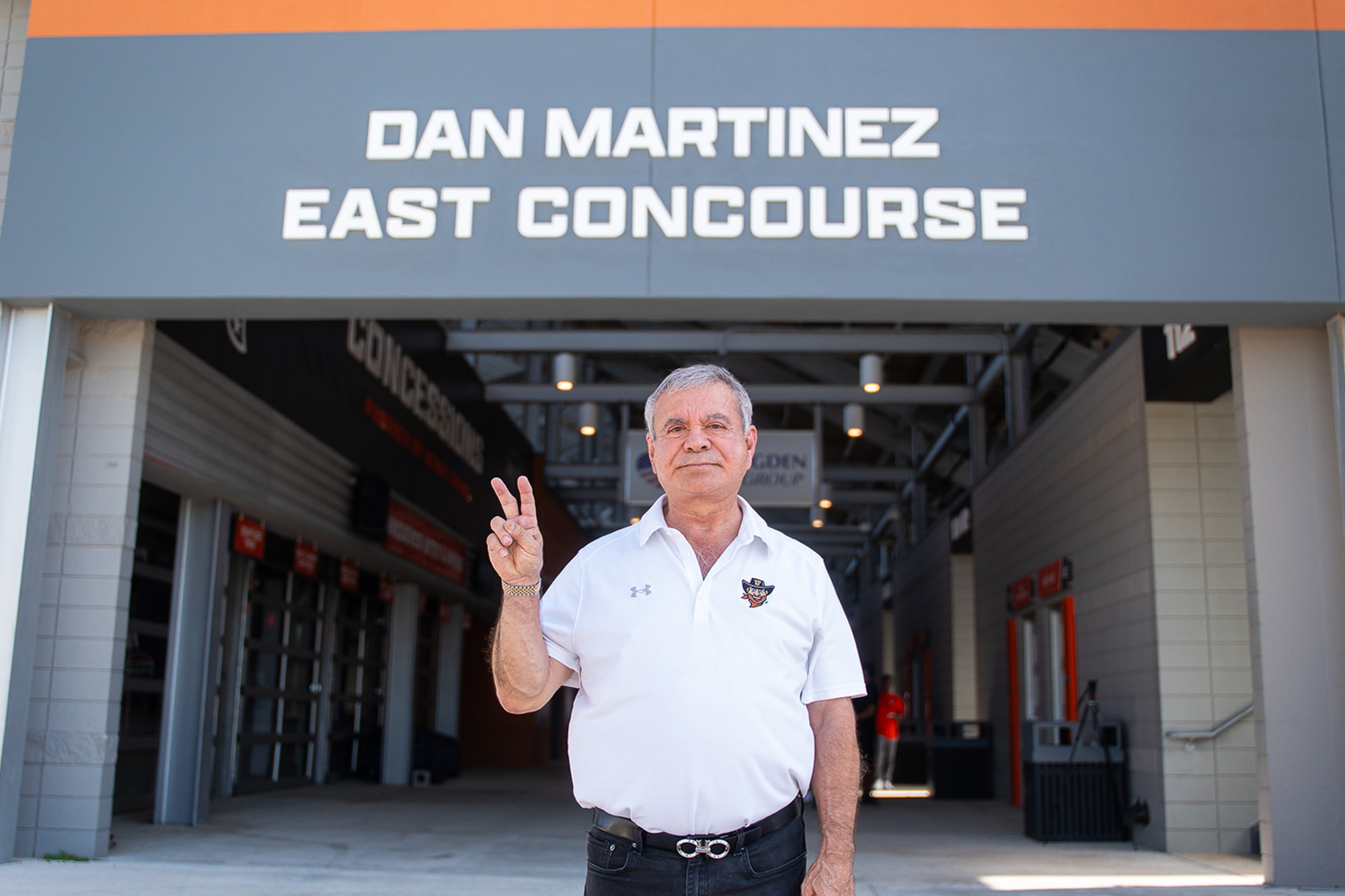 Dan Martinez Standing with his V's Up in Front of the Dan Martinez East Concourse