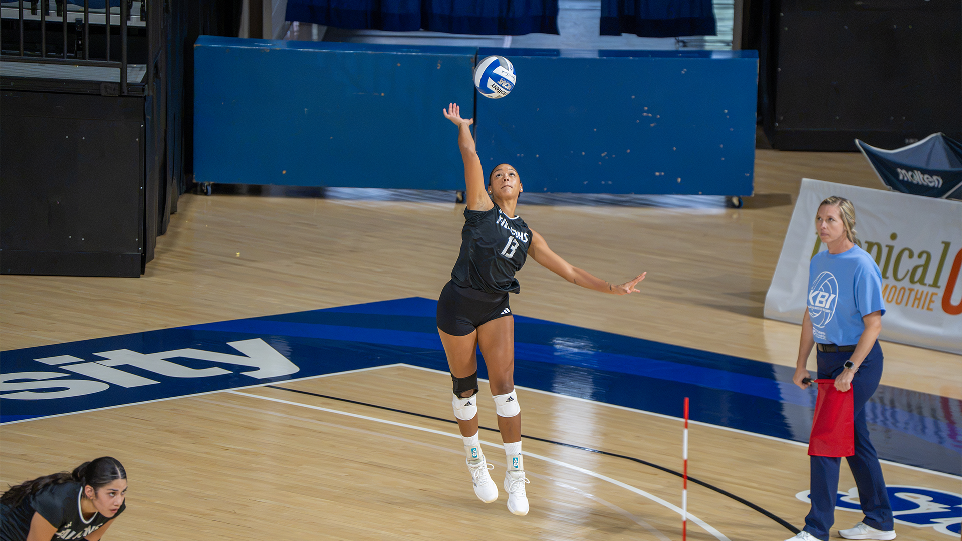Nickilah Whatley jumping up for the serve