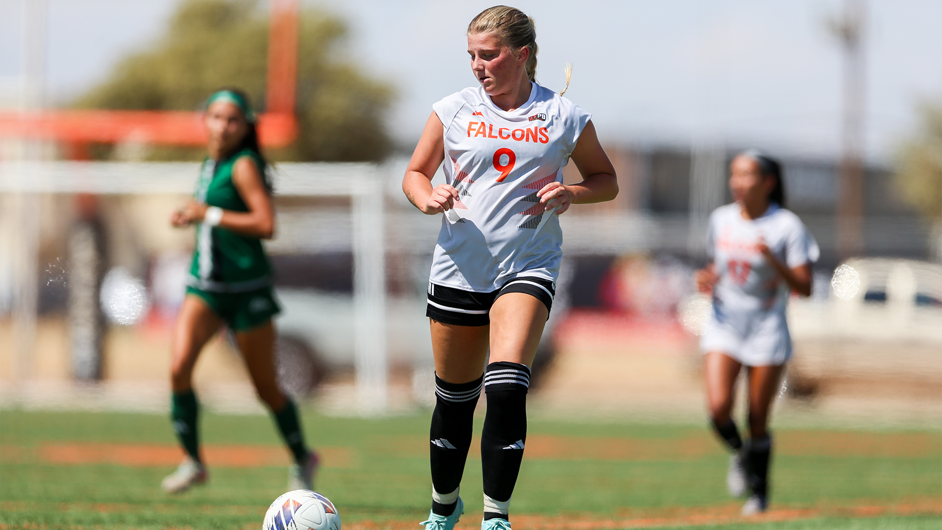 Molly King dribbles the ball up the pitch