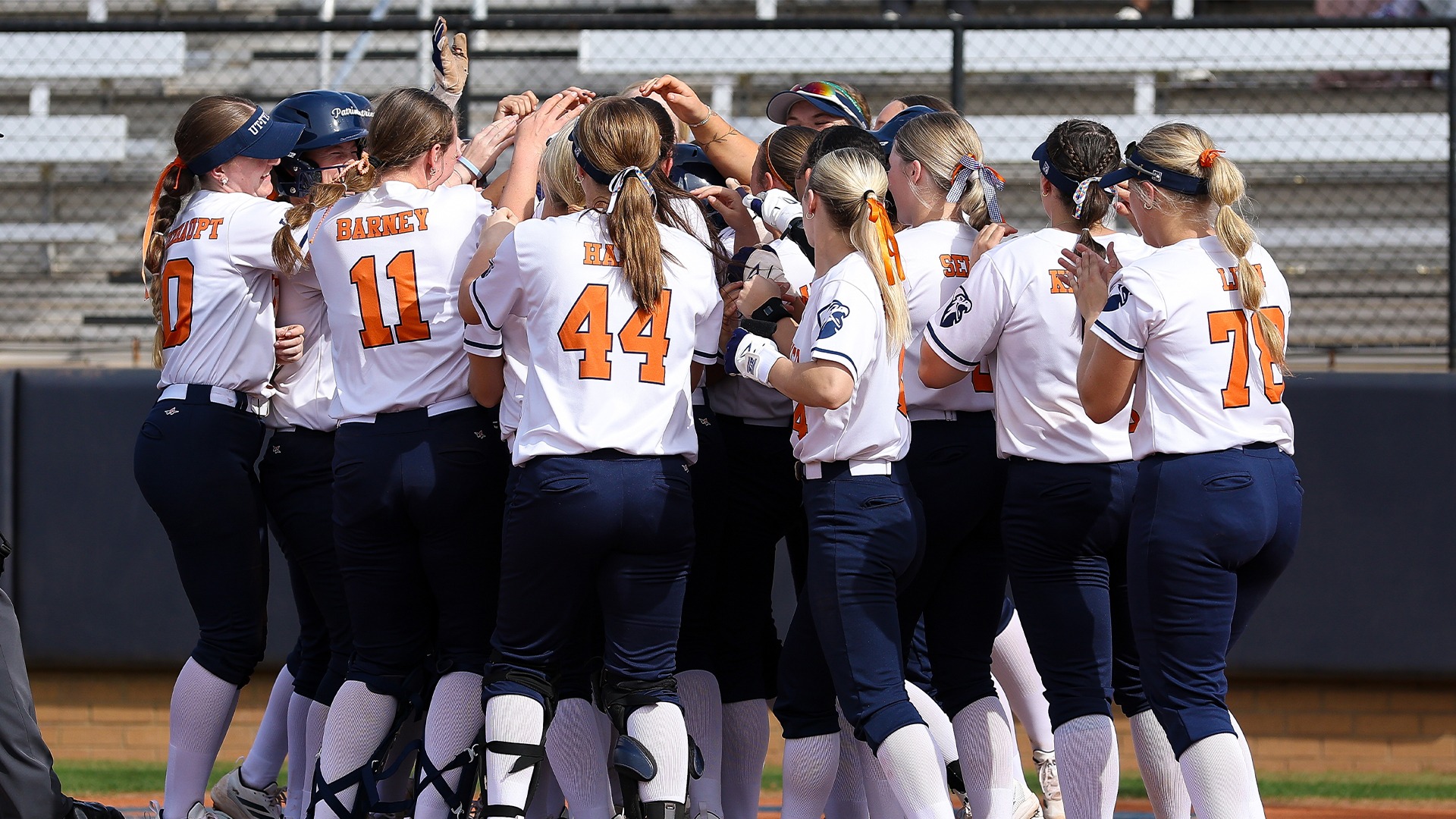 The Patriots crowd around the plate after a home run