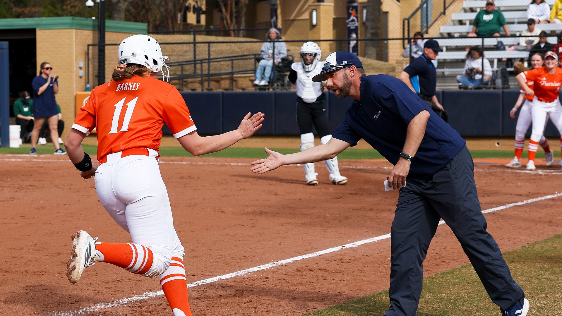 Taryn Barney high fives Coach Miller after rounding third on a home run.