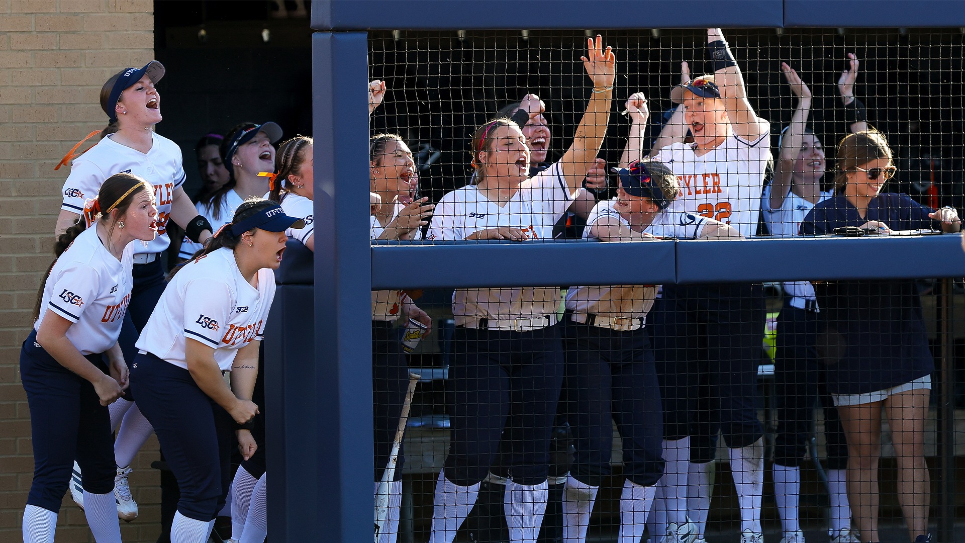 UT Tyler Softball's dugout celebrates a big hit.