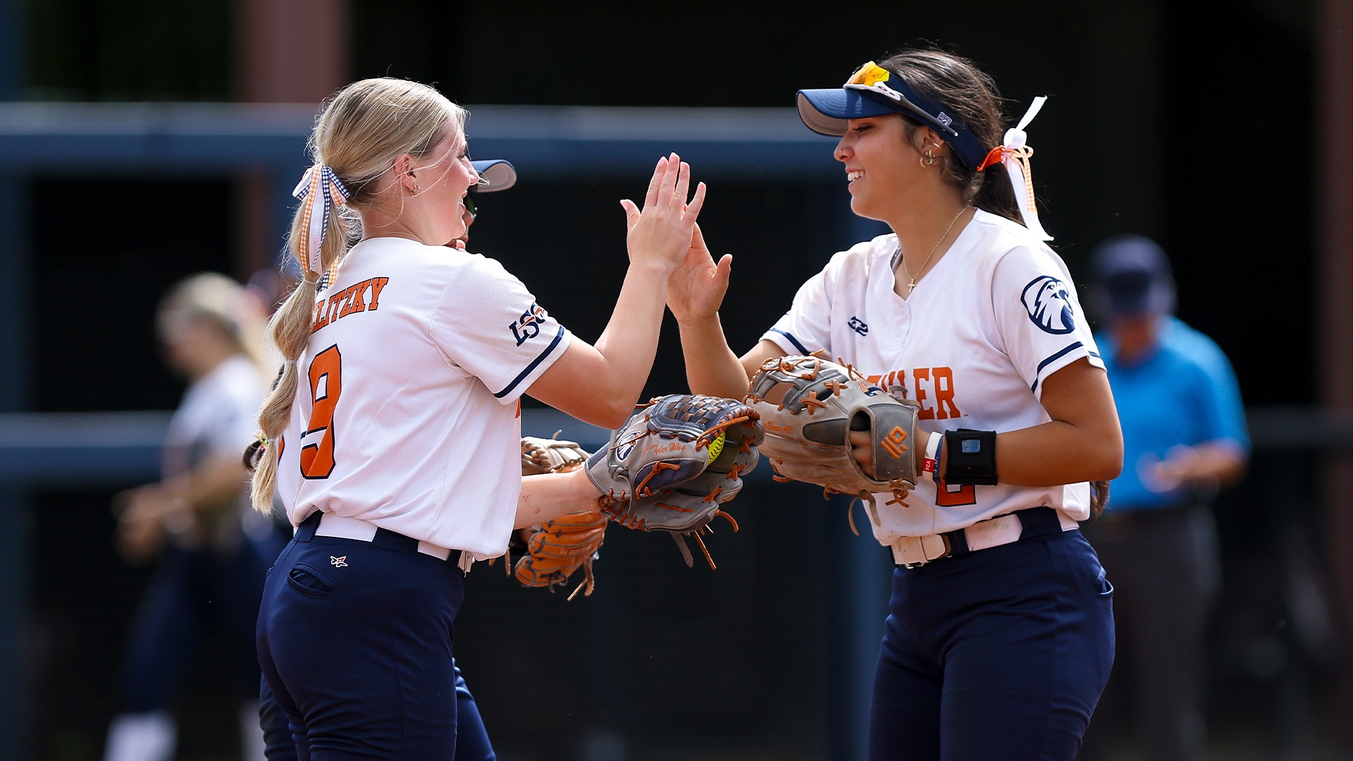Kaylee Cavazos, Kaelyn Lerma, and Kendall Selitzky high five during a Patriots sweep against Texas Woman's.