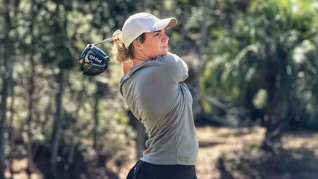 Women's golfer watches the ball after her swing -- 2025-26
