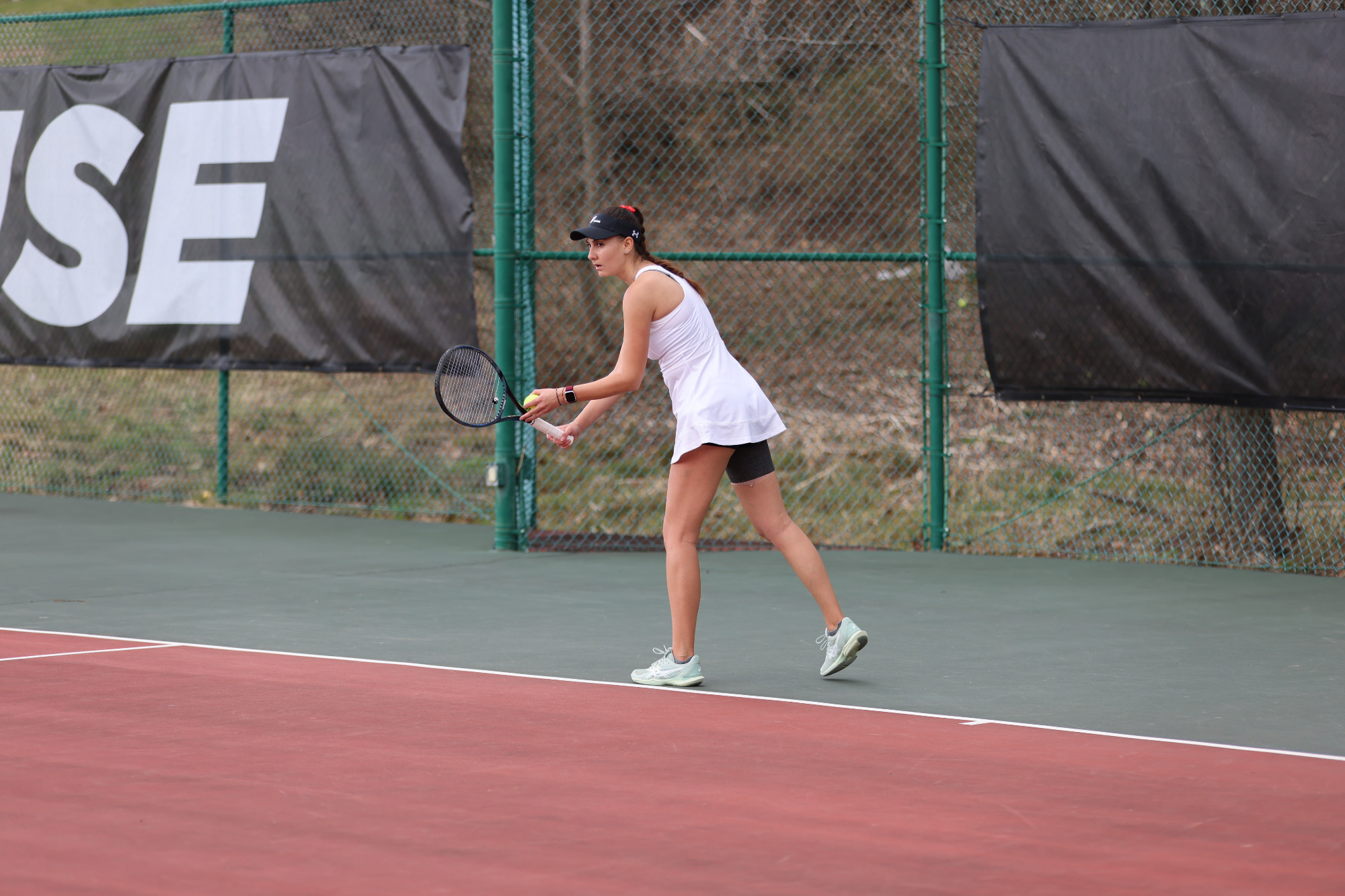 Women's tennis player serving against Indiana (PA)