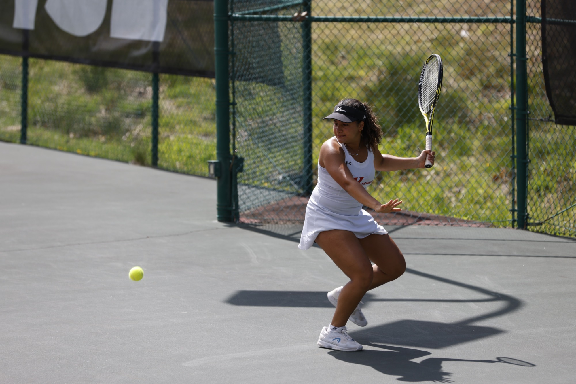 Women's Tennis Player hits the ball vs Emory and Henry -- 2025-26