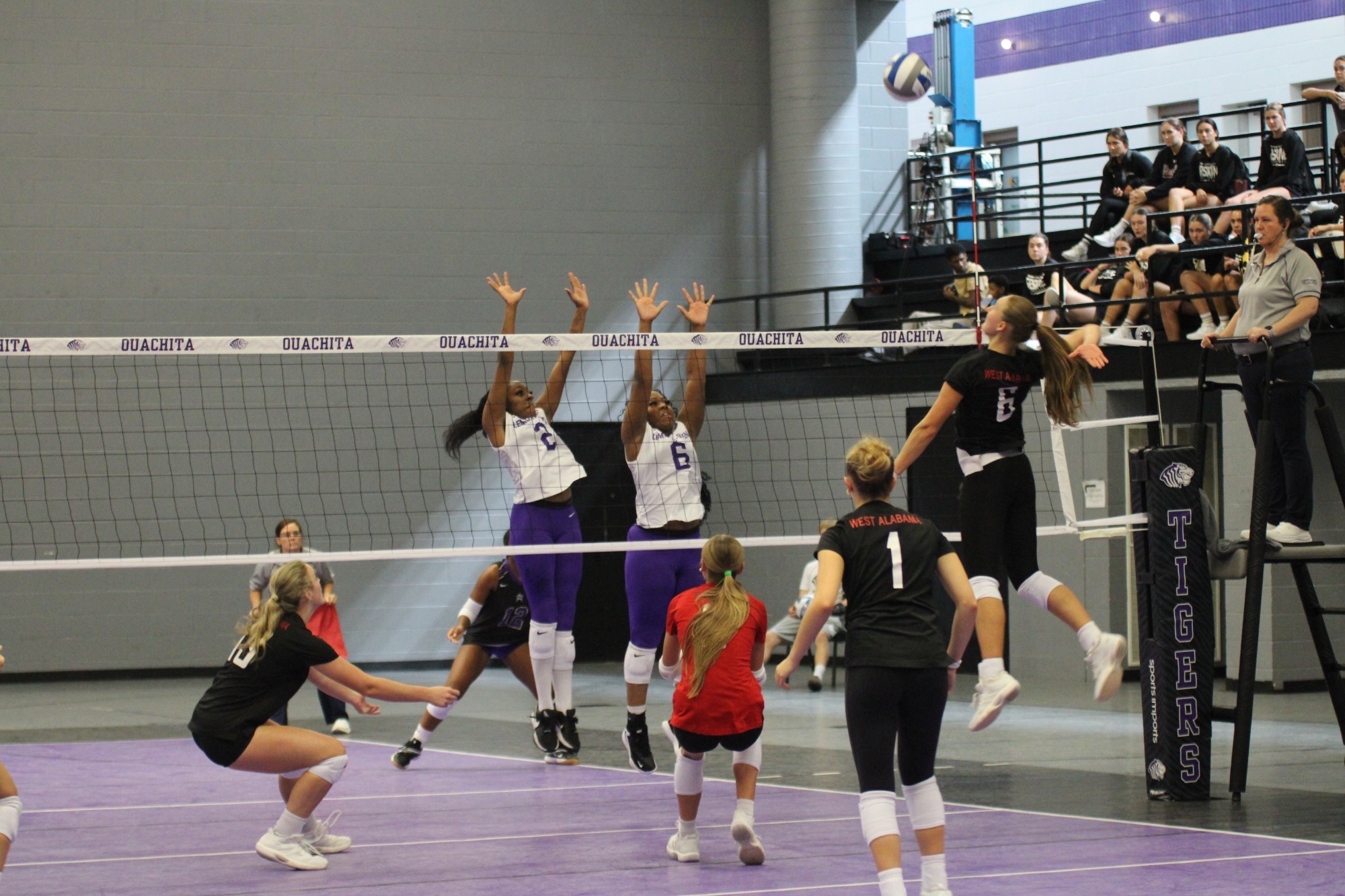 West Alabama volleyball player Klára Bobánová jumps to attack the ball against two LeMoyne-Owen blockers during the Reddie-Tiger Invitational in Arkadelphia, Arkansas.