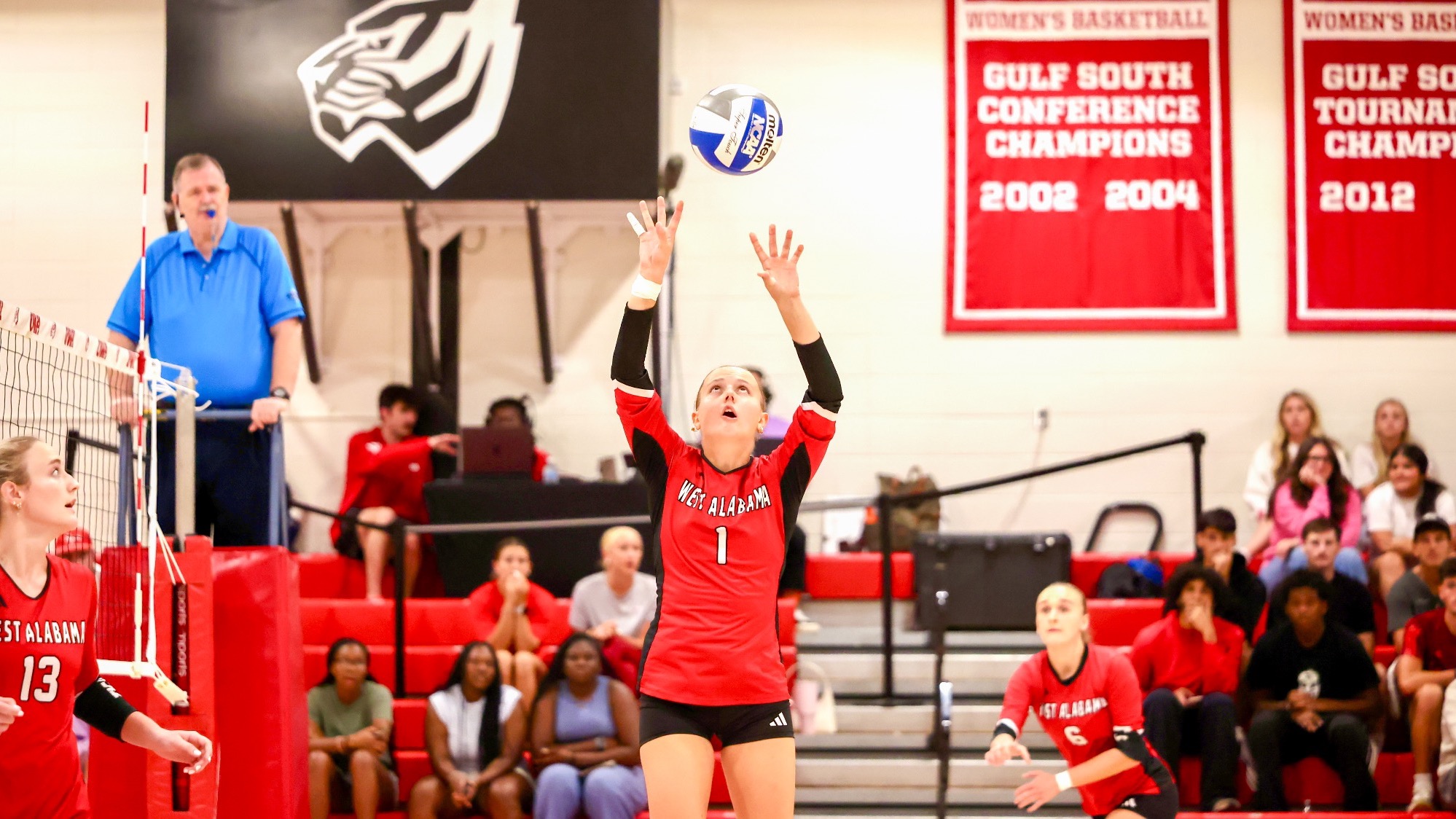 West Alabama setter Rachele Zanini (1) sets the volleyball above her head during a match inside Pruitt Hall, with teammates positioned around her.
