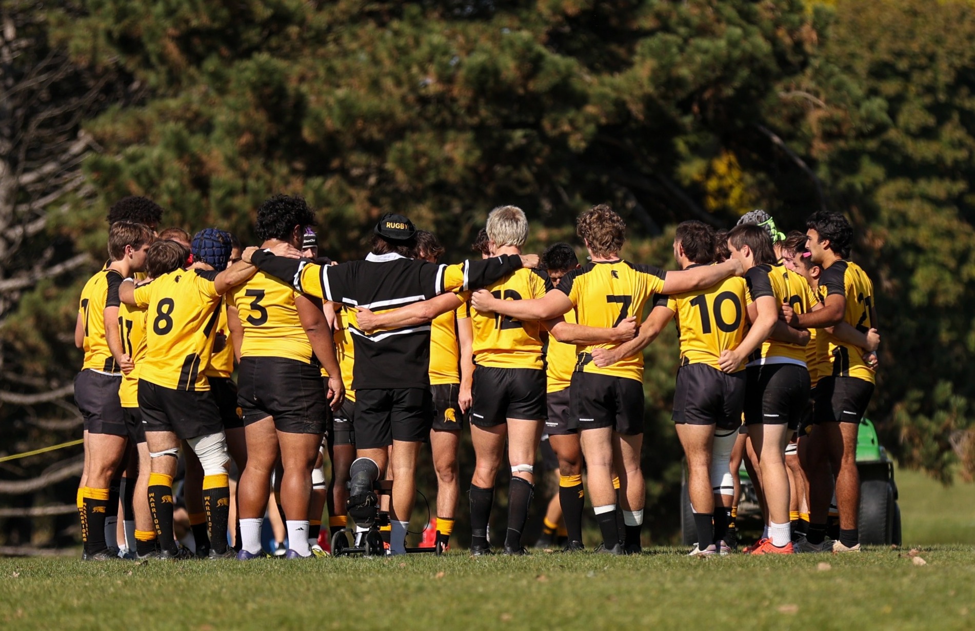 Warriors stand together in huddle.