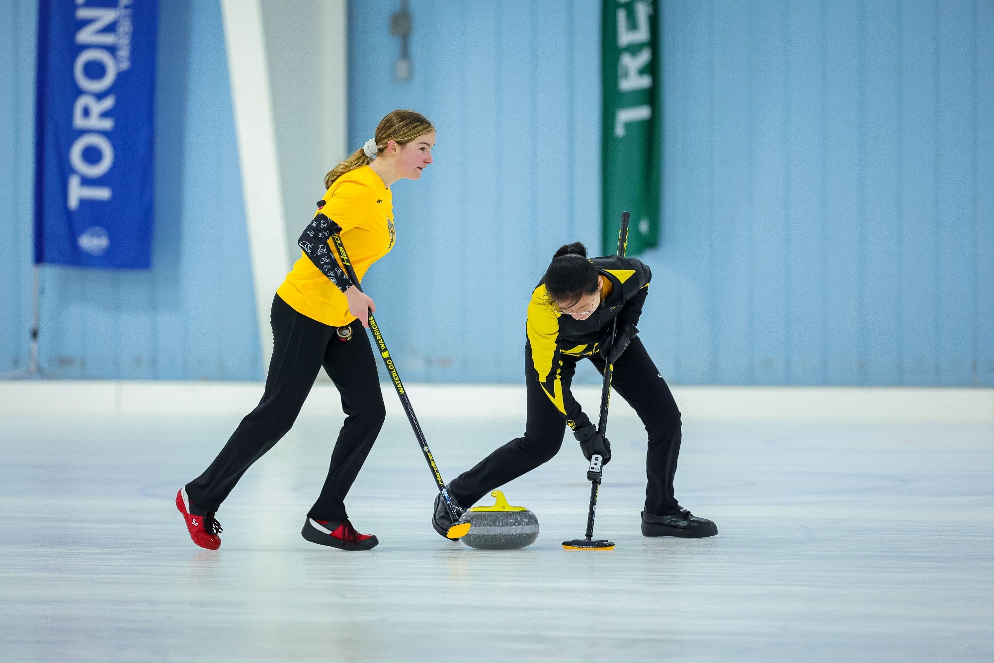 Warrior curlers sweep the rock as the head to the end