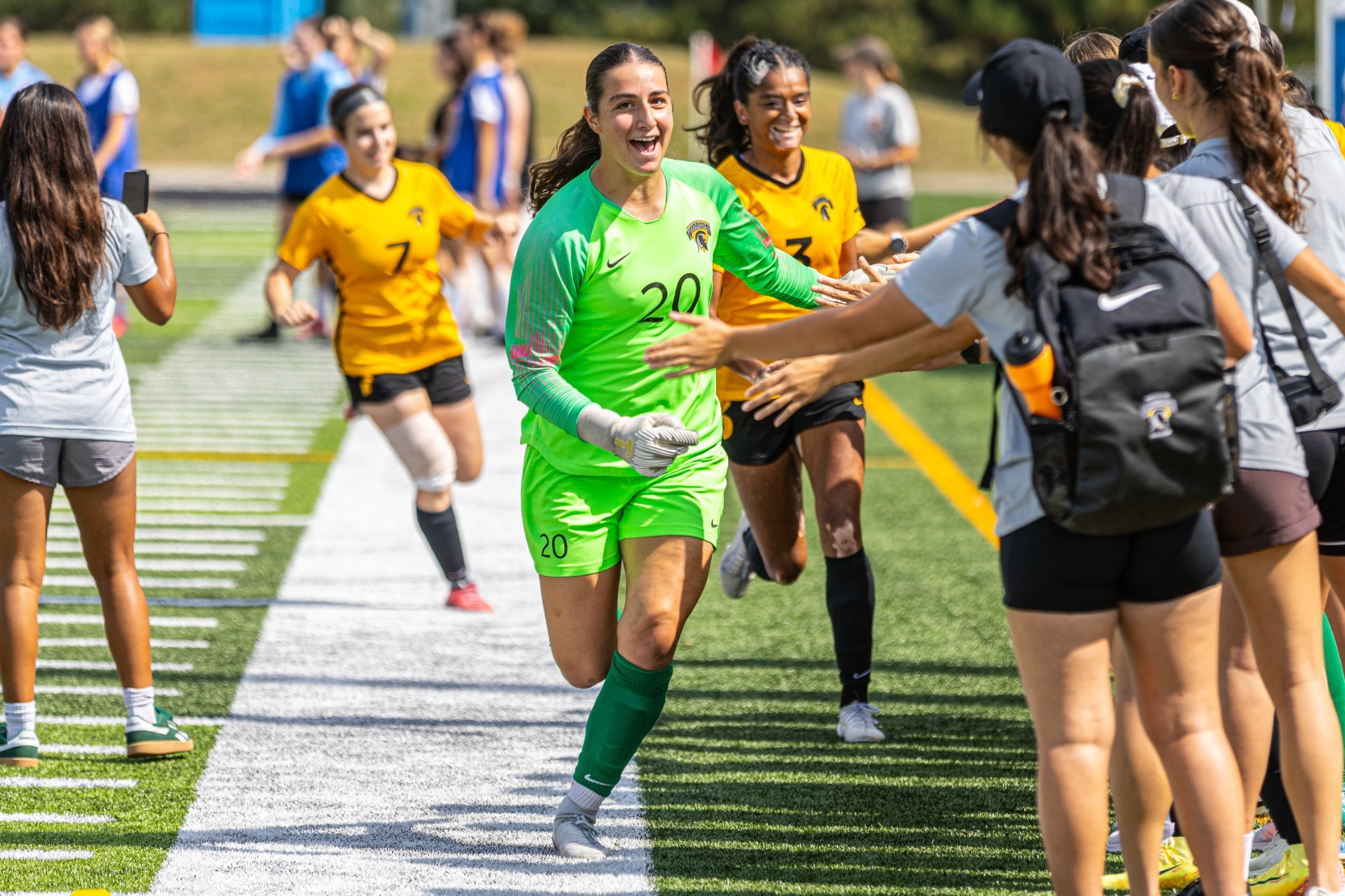 Warriors Goal Keeper gives high five to players on the sideline 