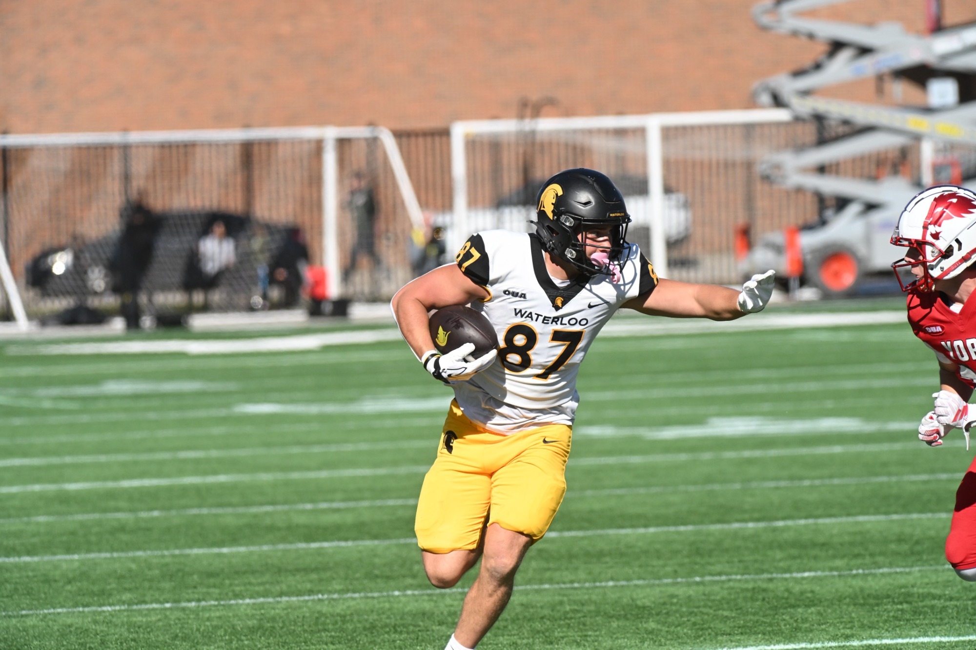 Evan Basalyga stiff-arms a York Lion