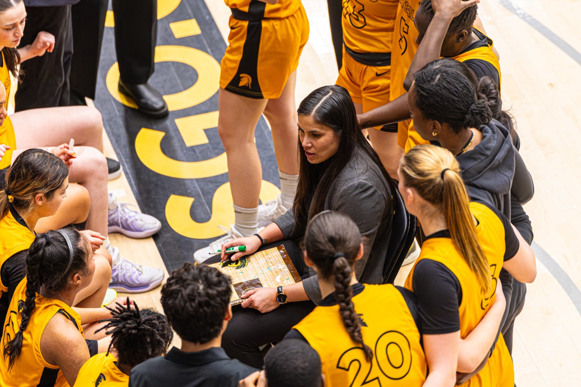 Coach Jessica Roque huddles with her team