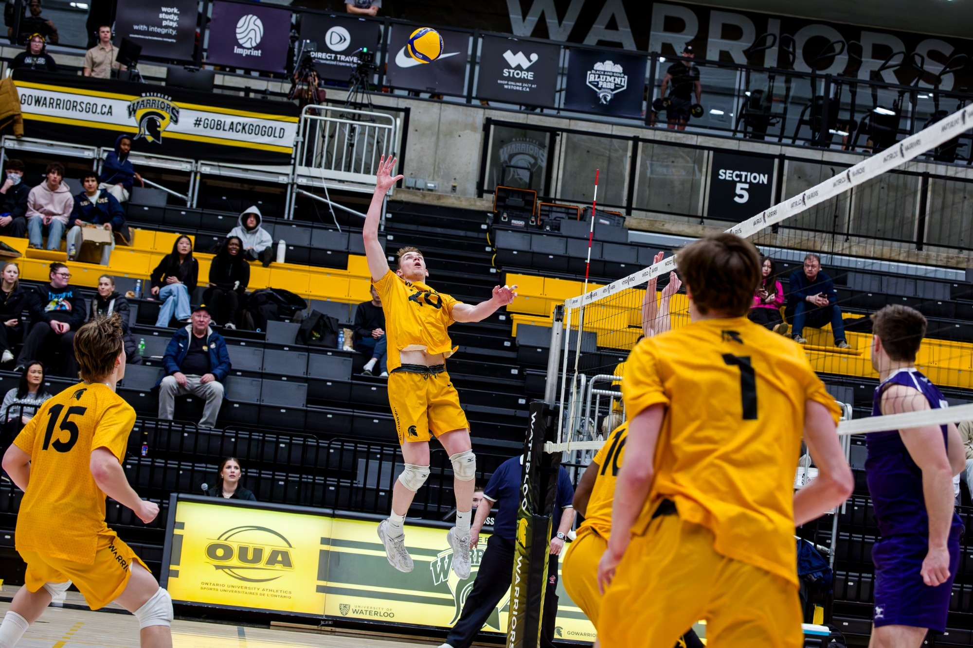 Lucas Redmann leans back in the air to reach a high arching set.