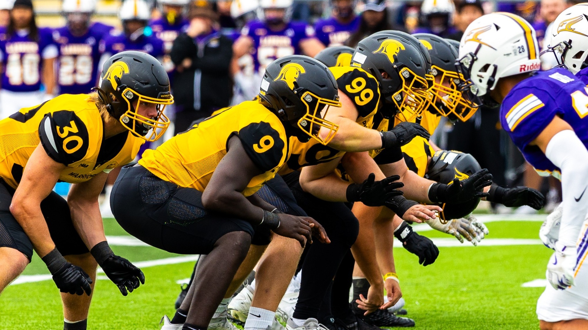 Michael Omoseni and the Warriors D-line line up for a play