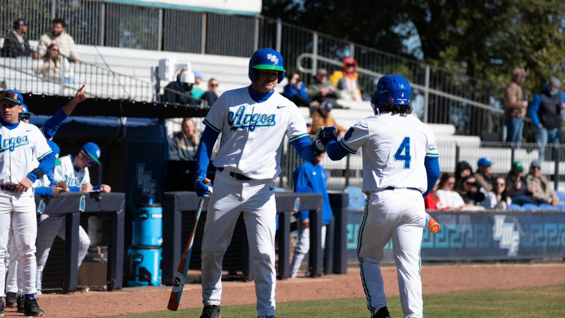Two baseball players fist bump at home plate