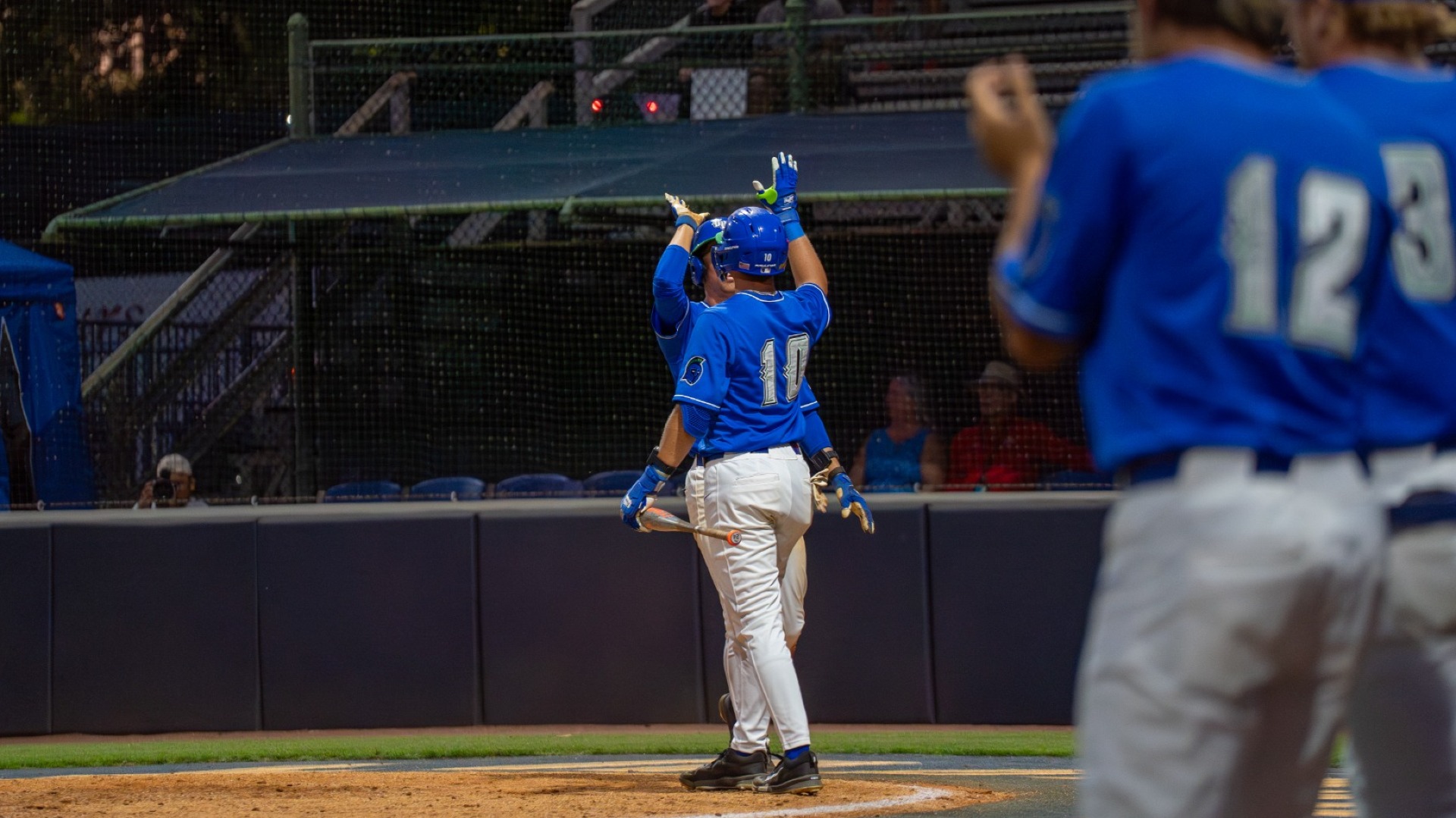 two players celebrate at home plate
