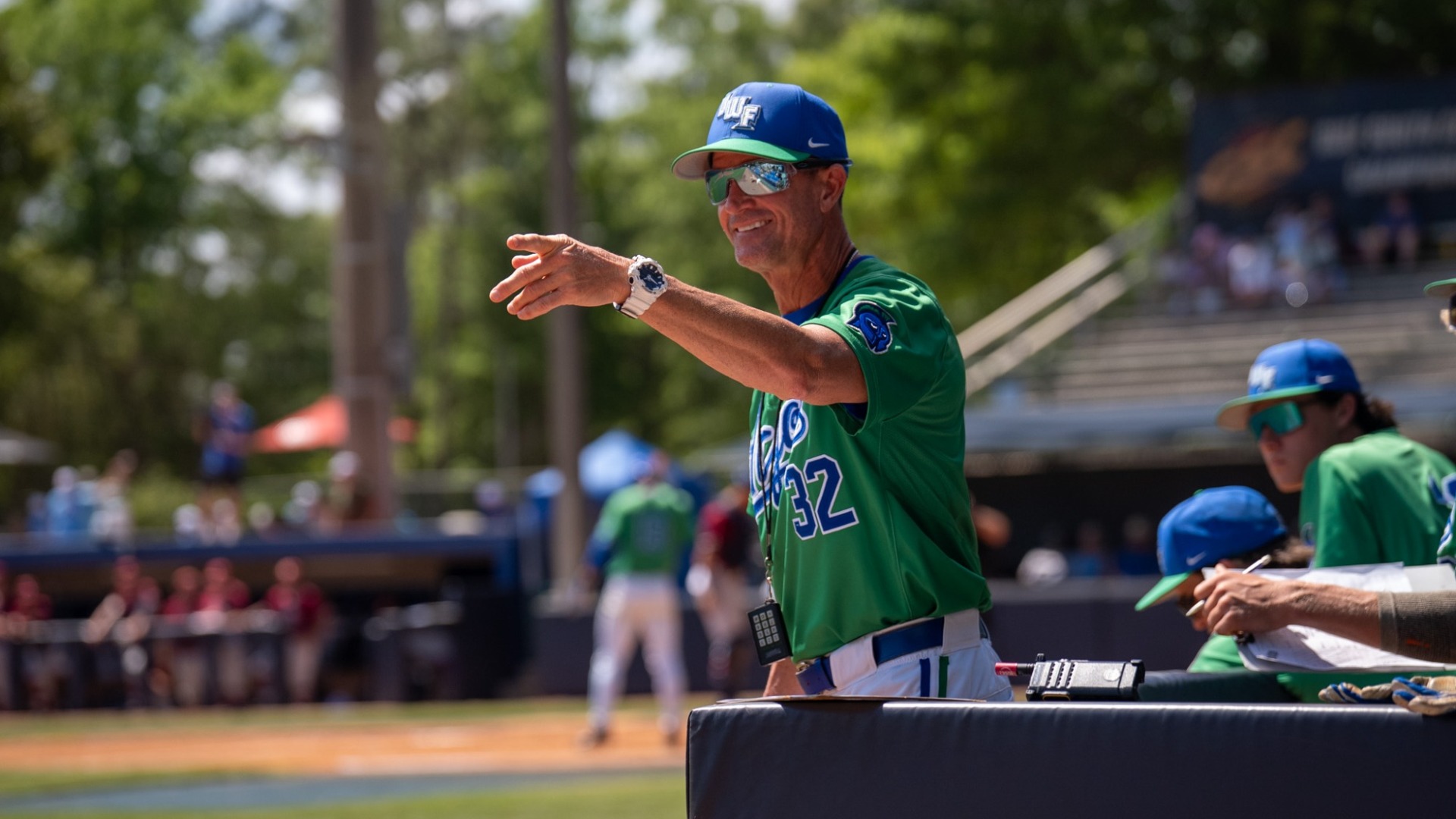 Coach Jeffcoat pointing out into the field and smiling