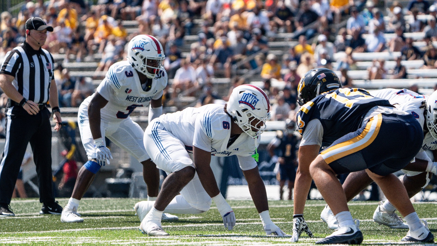 Elijah Barnes (6) and Chidu Bekee (3) line up defensively for the Wolves in a football game against ETSU. They are wearing UWG's all-white road uniforms.