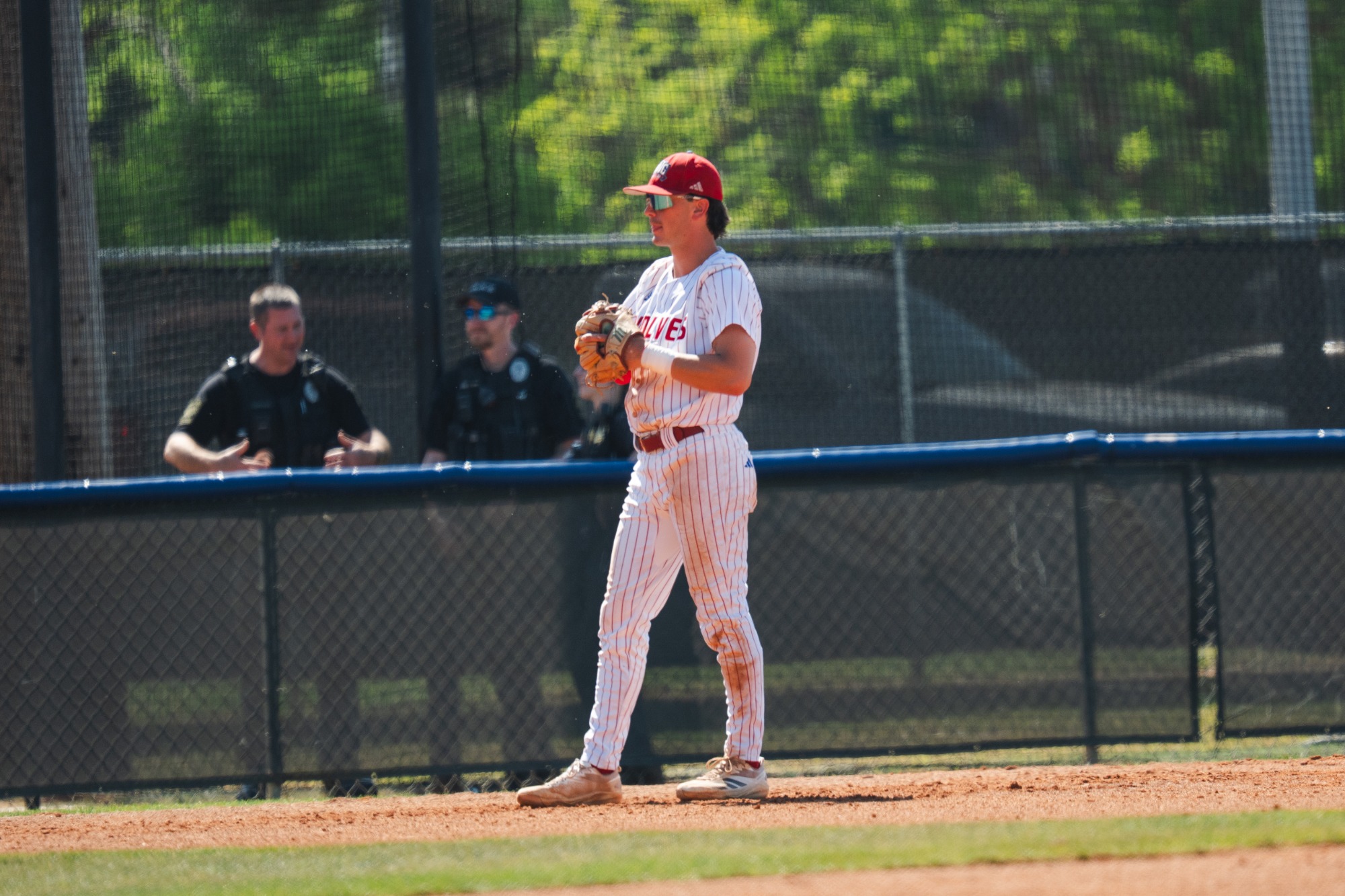 UWG baseball player in white waiting to react to UNF at-bat. 