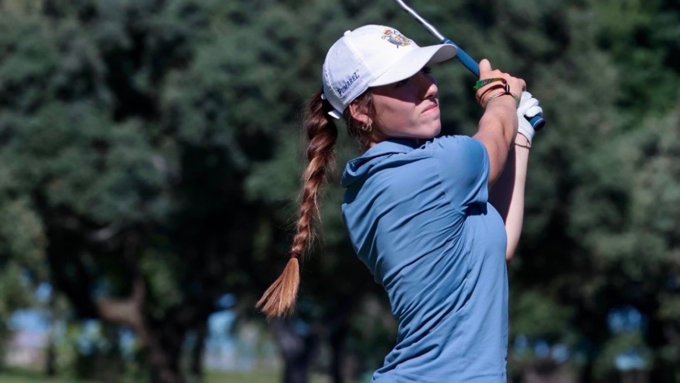 Alba Caliz Rejas holds the finish of her golf swing.