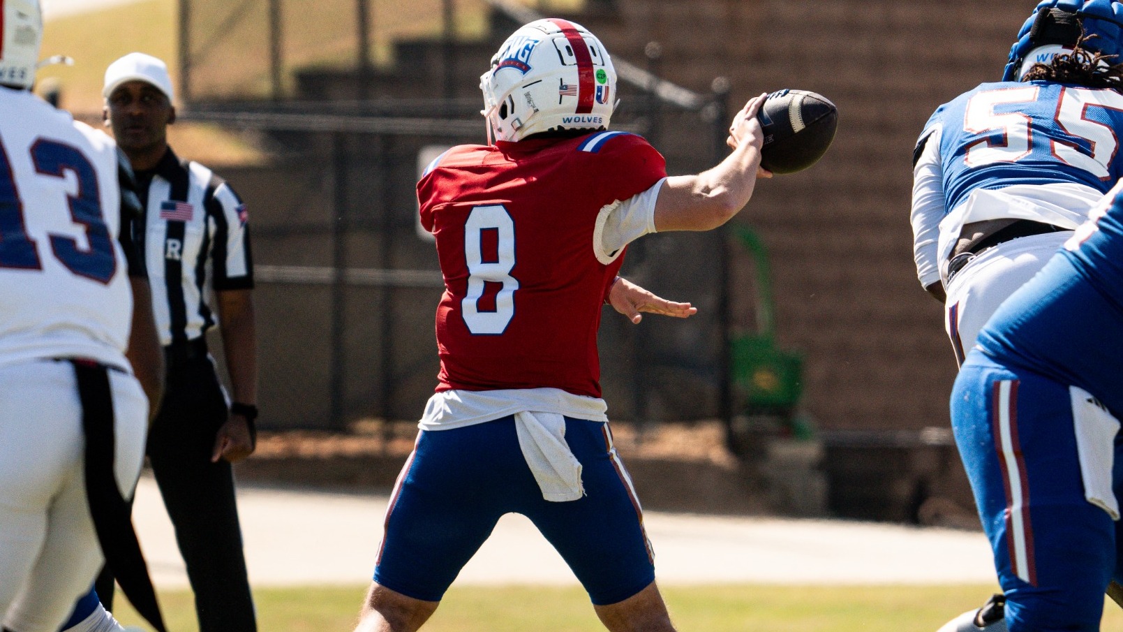 Quarterback Collin Hurst passes during the UWG Spring Game. Hurst is wearing a white helmet, a red jersey, and blue pants.