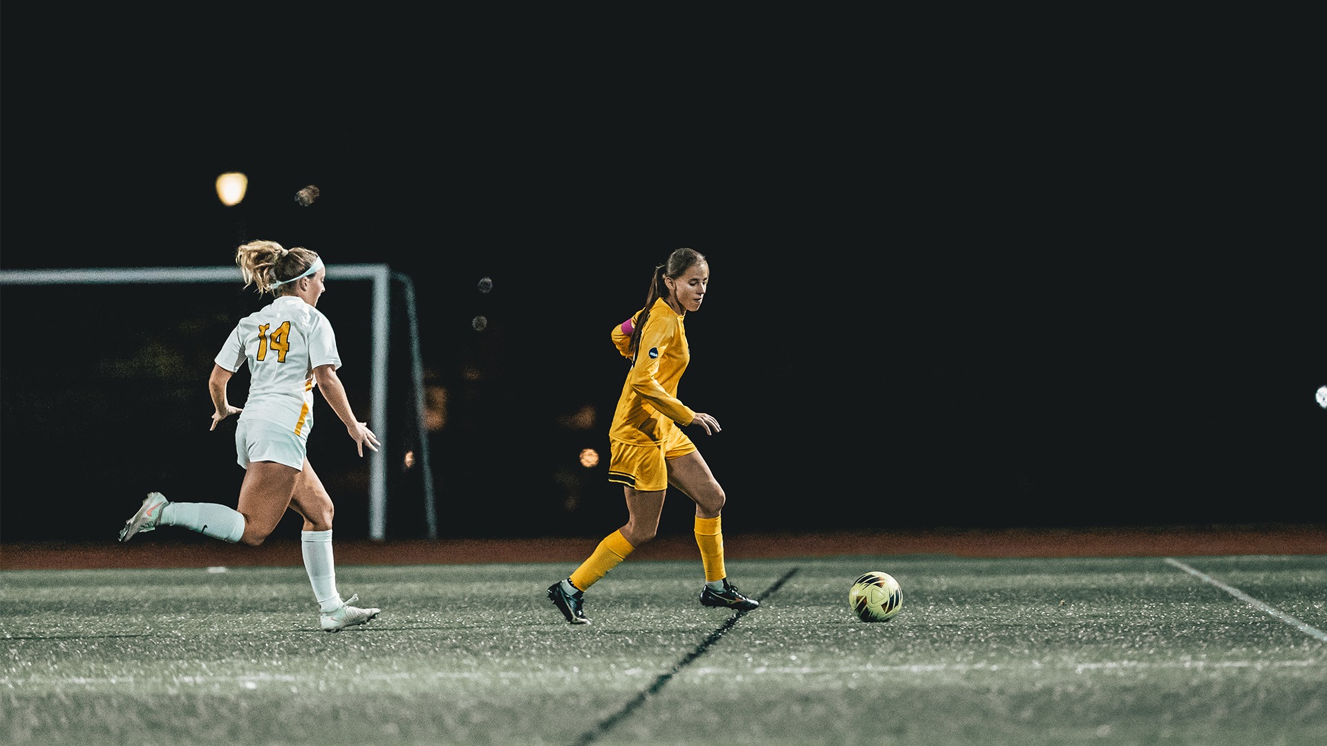 Taylor DeCook with possession of the ball in front of a defender.