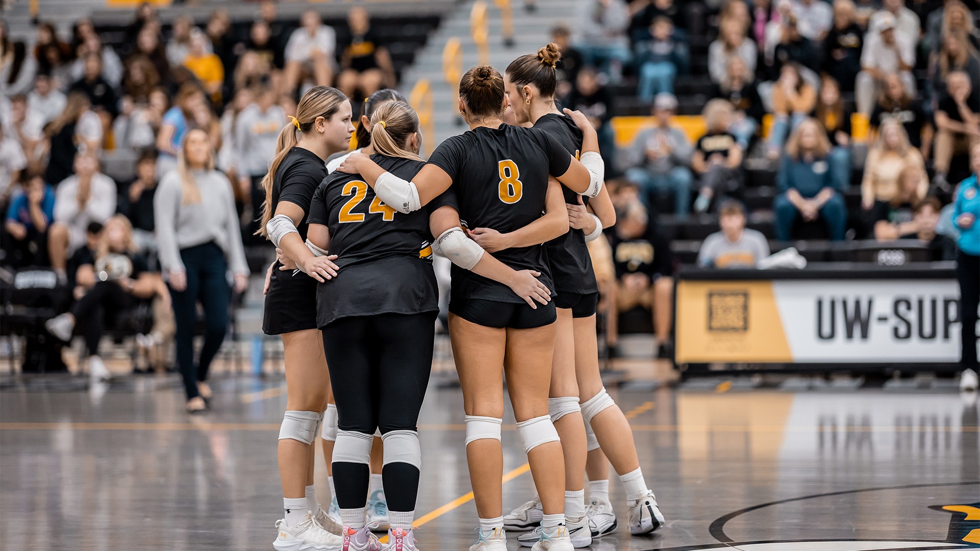 The volleyball team in a huddle.