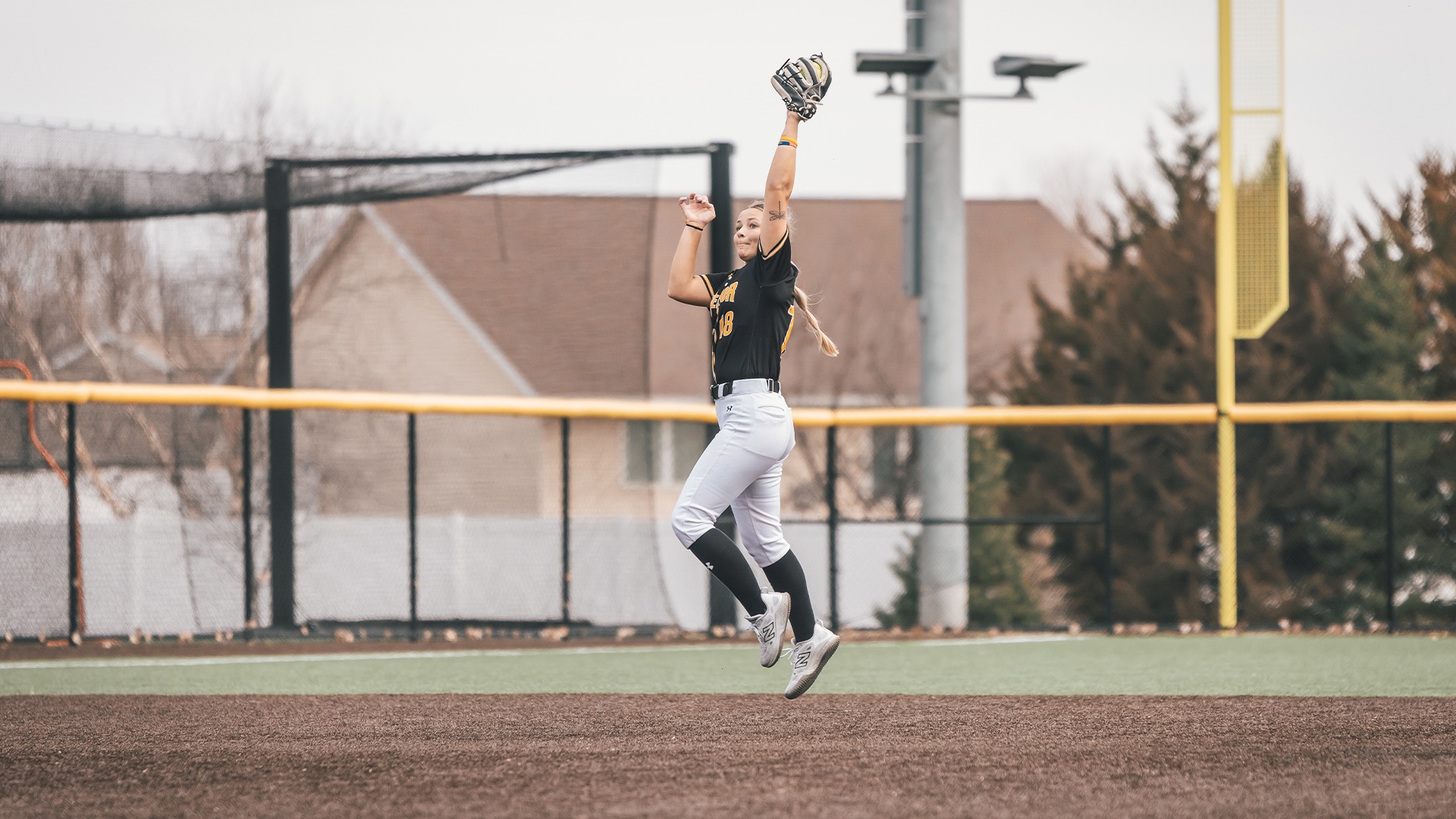 Kylie Zwak leaping in the air to catch a ball.