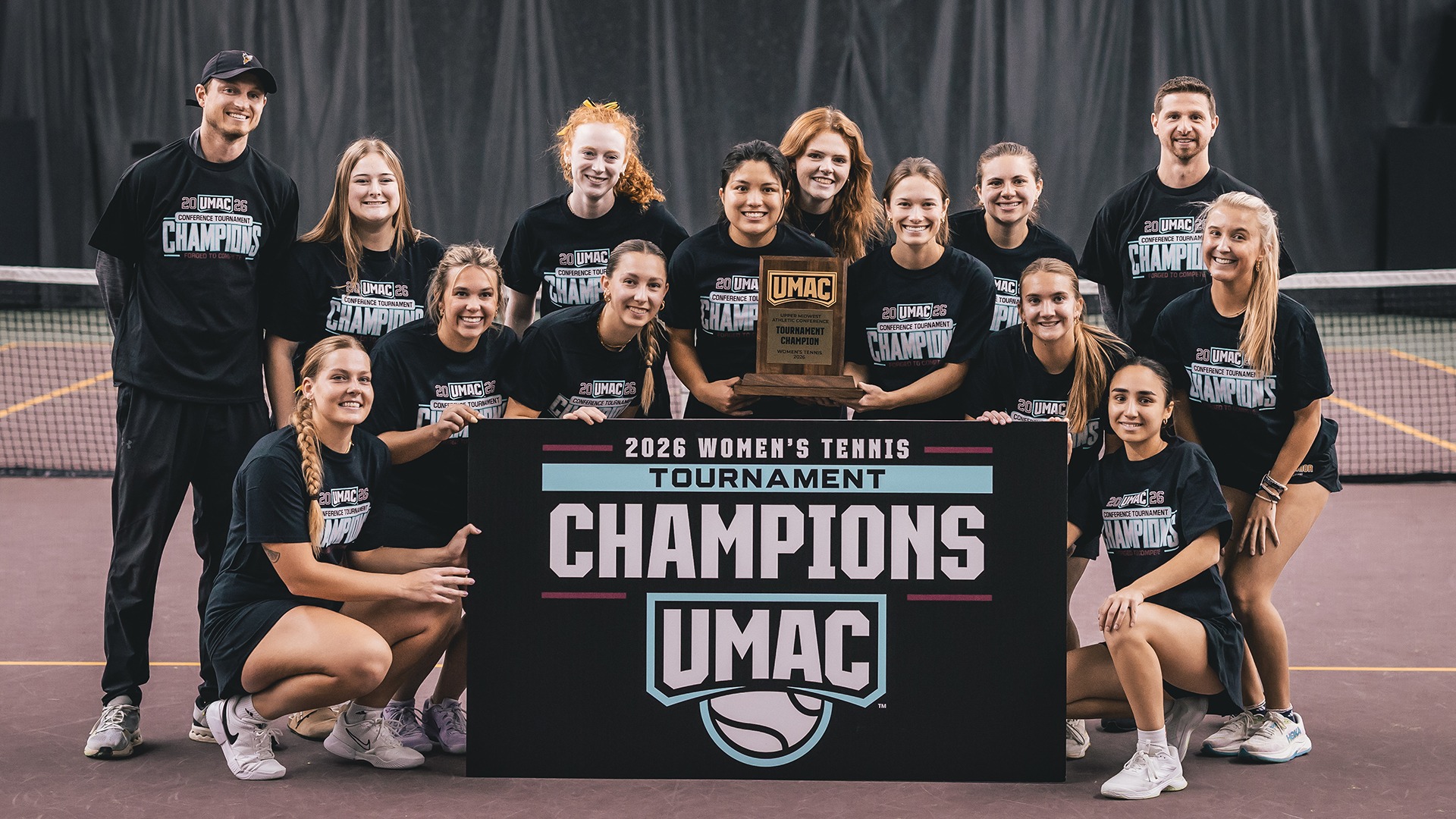 Women's Tennis celebrate with their UMAC trophy. 