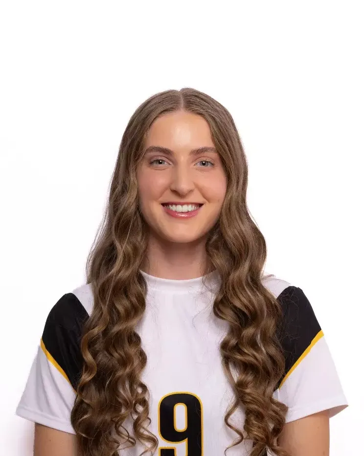 A headshot of a woman in a white jersey