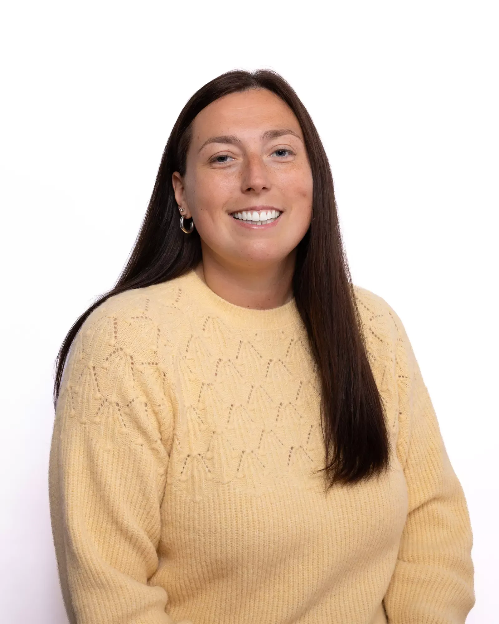 Headshot of a woman in a yellow sweater