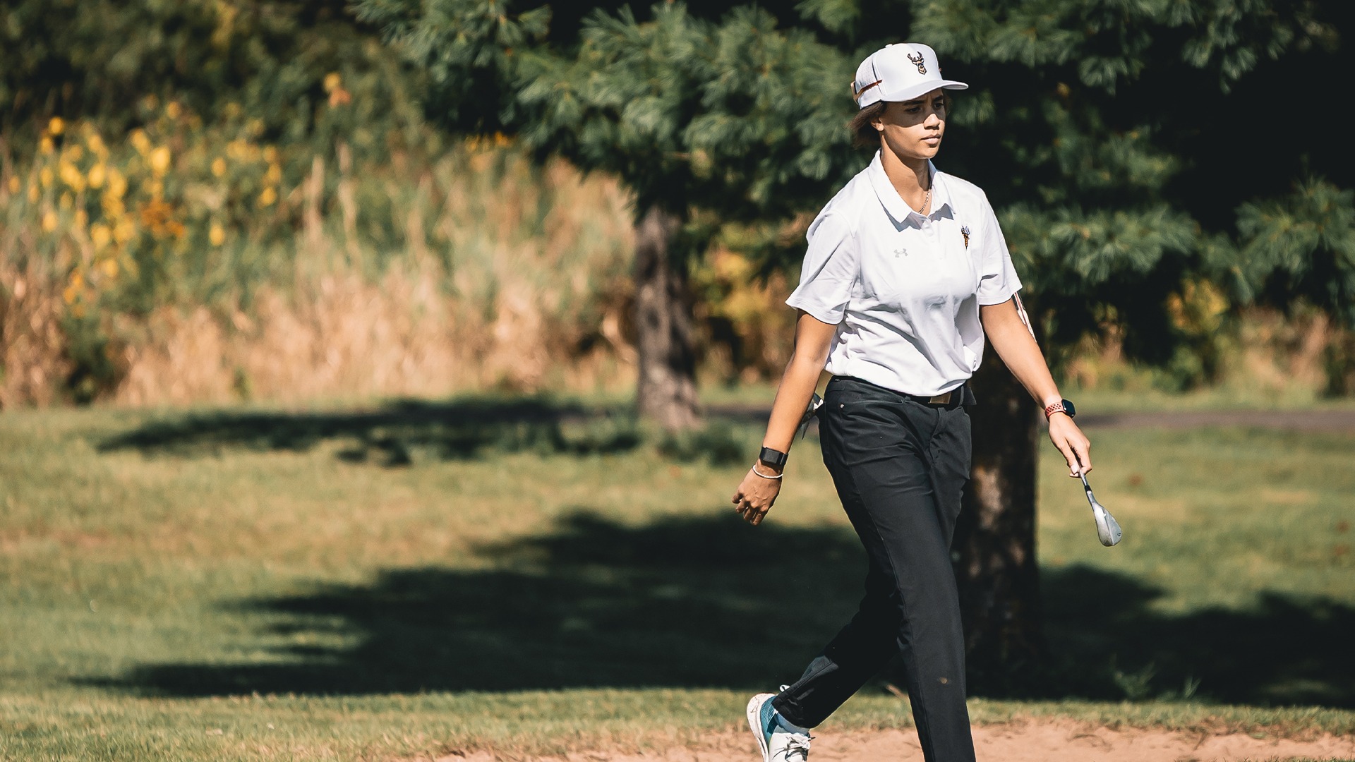 Makayla Ammerman walking with a golf club in her hand.