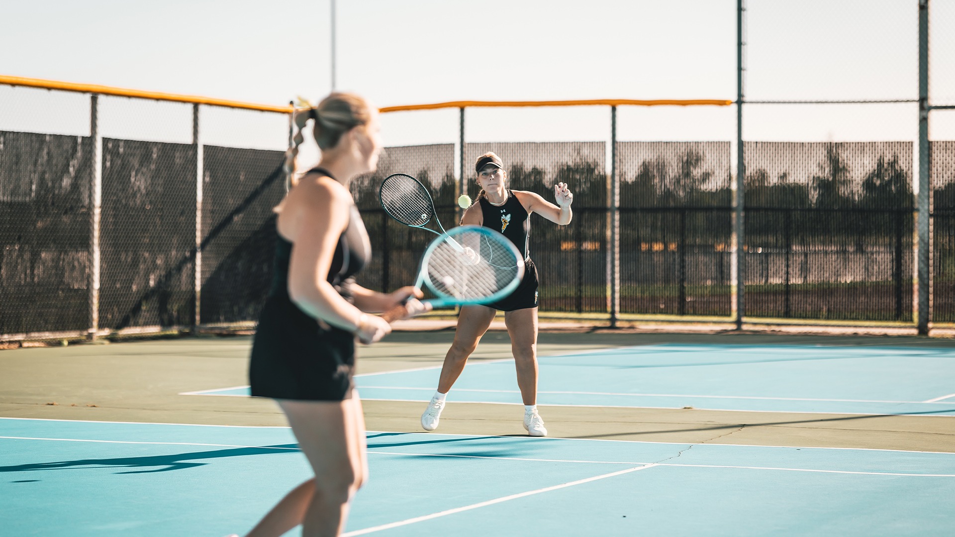 Kate Jonas making contact with a forehand tennis shot.