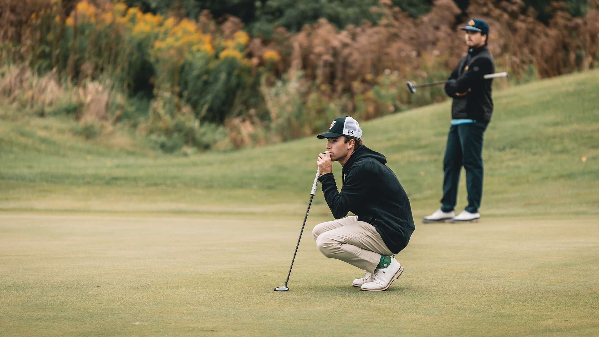 Matthew Unger reading the green preparing for a putt.