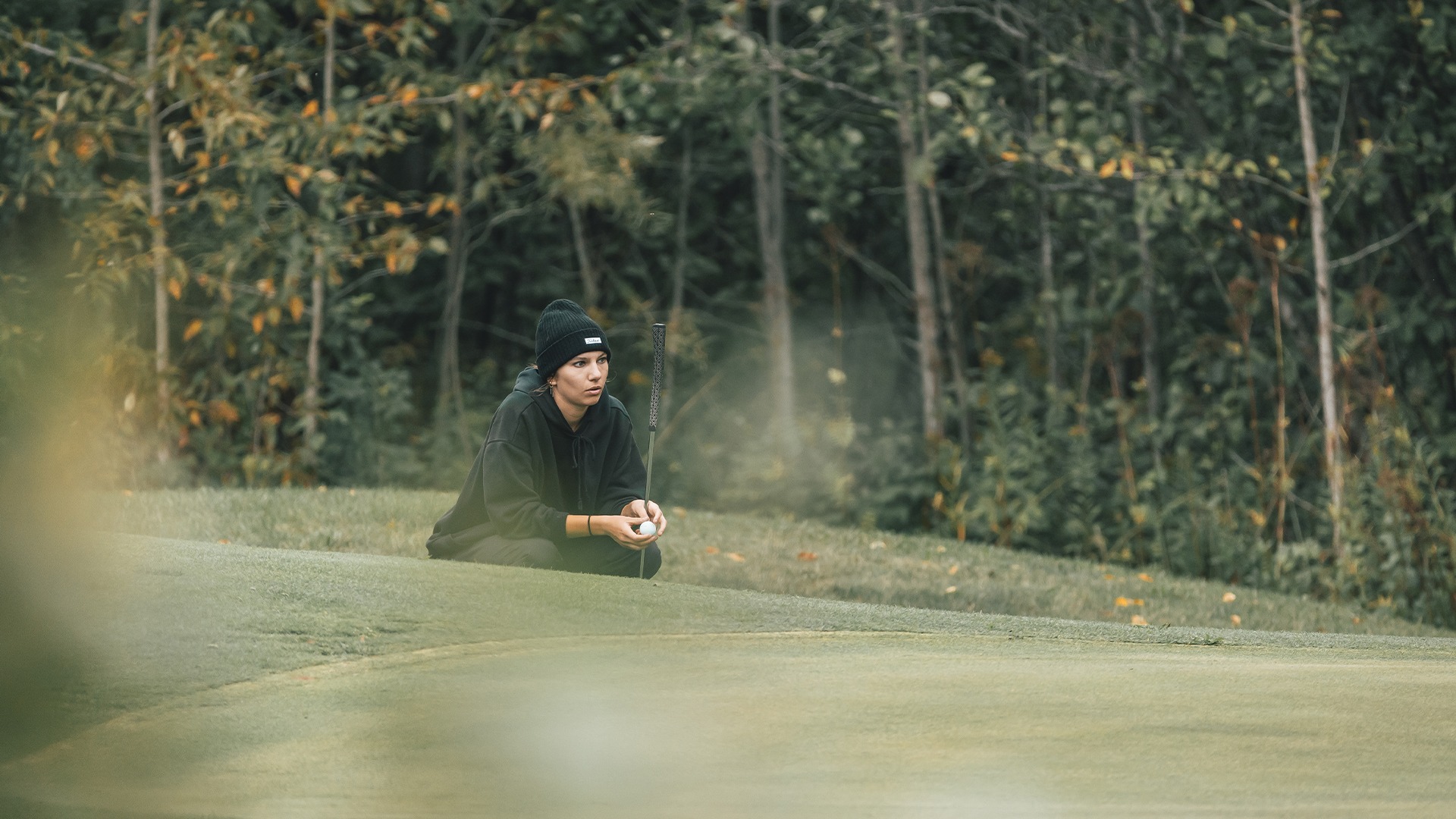 Abby Schintz observing the green from the first cut of rough.
